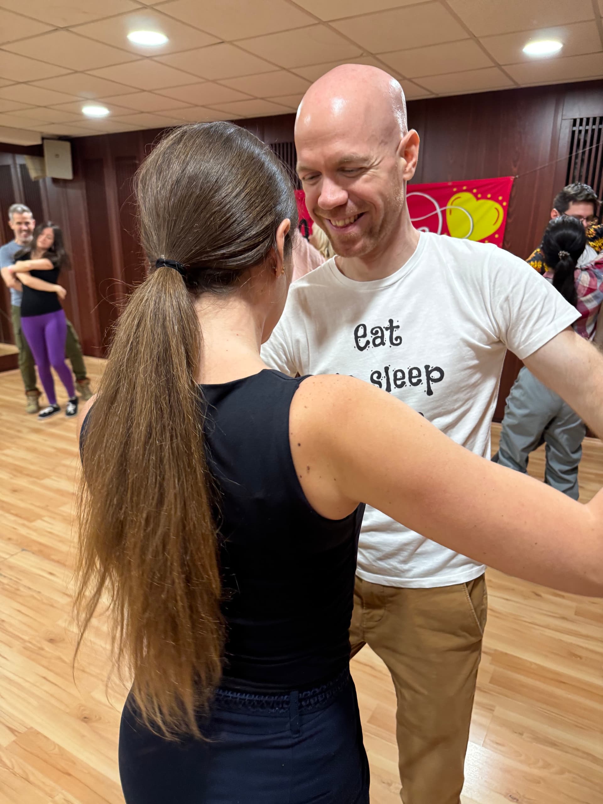 Mosolygó bachata páros kapcsolódik tánc közben egy Four Steps órán